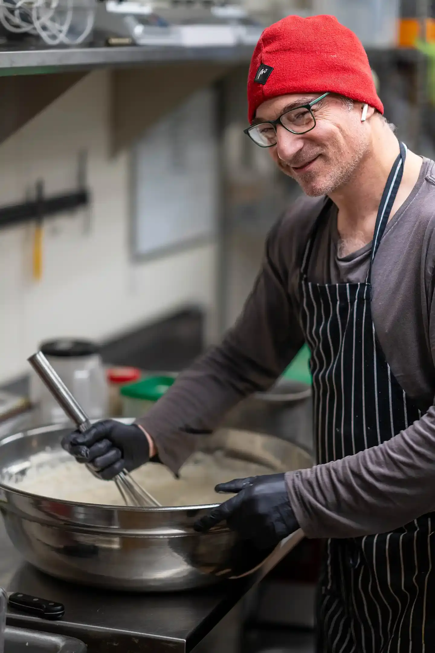 A picture of a smiling chef in a commercial kitchen